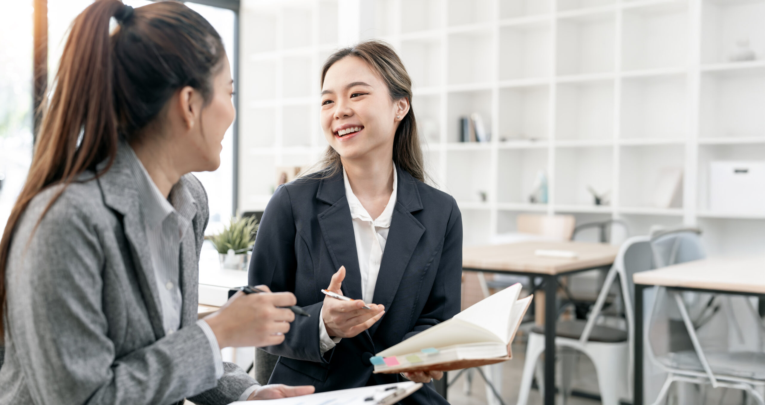 Business woman colleagues having a conversation and discussing project plan together at office.